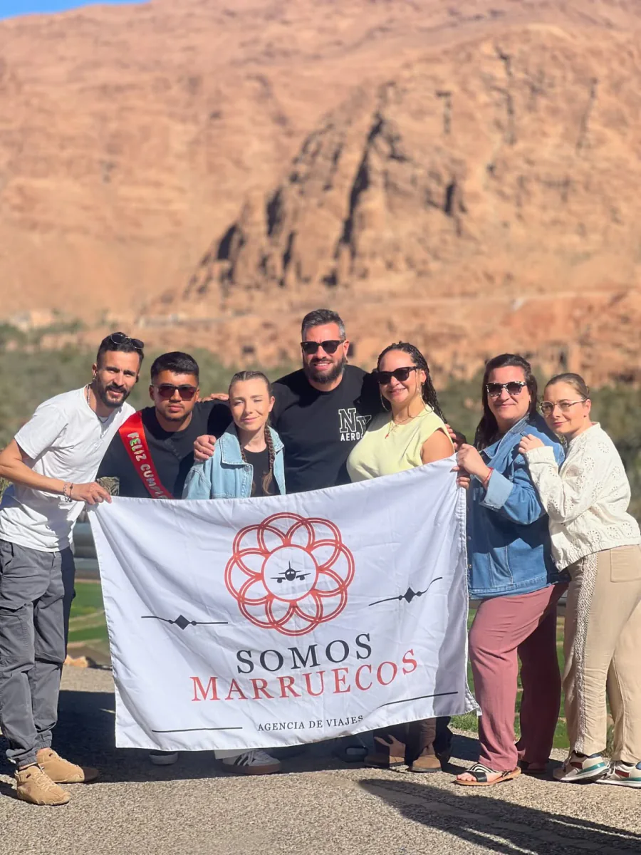 Viajeros sosteniendo la bandera de Somos Marruecos